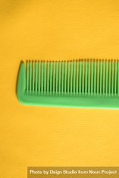 Bright green hair comb in yellow scene 5kRE16