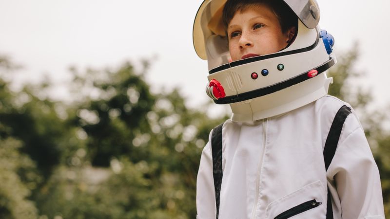 Boy playing to be an astronaut with space helmet and suit