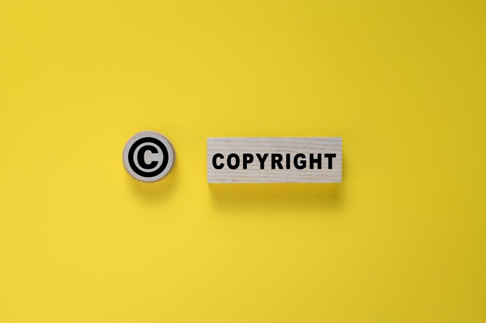 copyright symbol and word on wooden blocks. isolated on yellow background