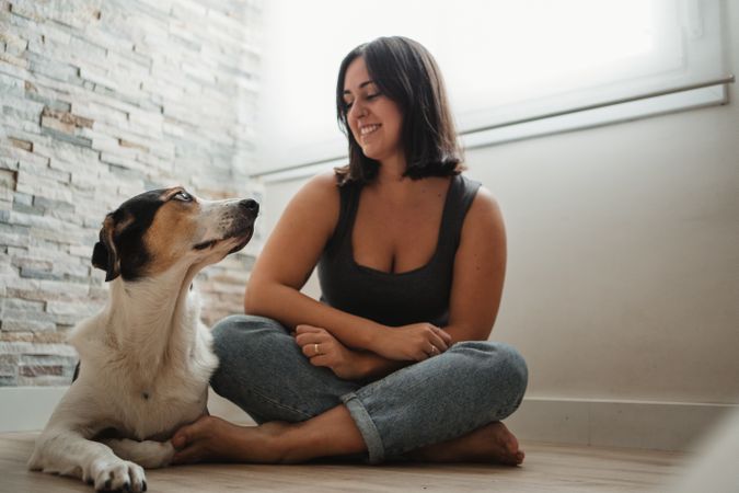 Woman with dog sitting on floor
