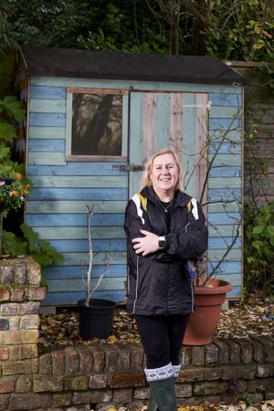 Woman standing outside wooden shed