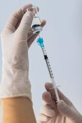 Hand holding syringe with vaccine. Close- up. Vaccination concept, health. Covid-19