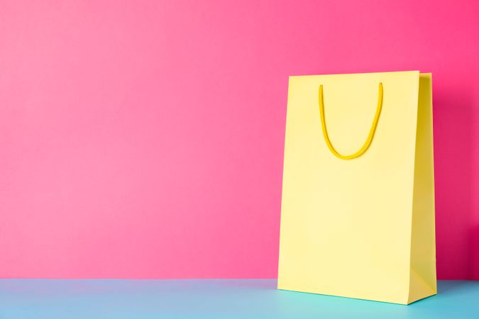 Yellow paper bag on multicolor background, space for text
