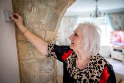 Woman adjusting thermostat