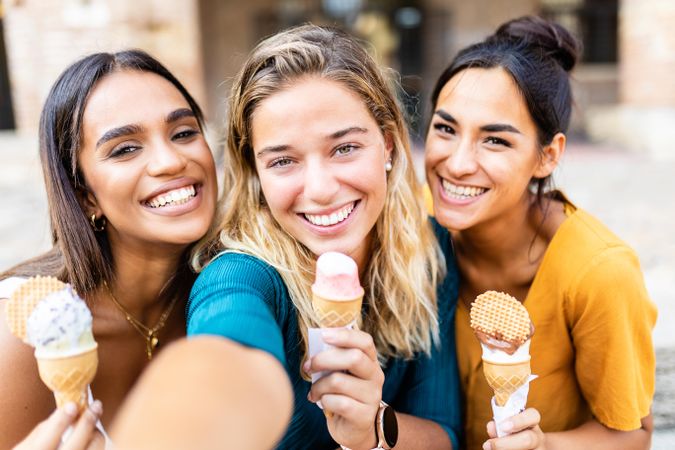 Selfie of three young women eating ice cream