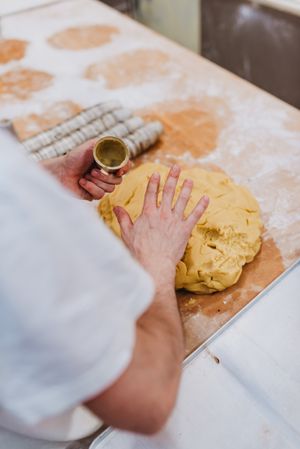 Bearded confectioner putting dough into cup