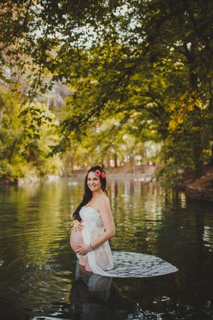 Pregnant woman standing in lake water