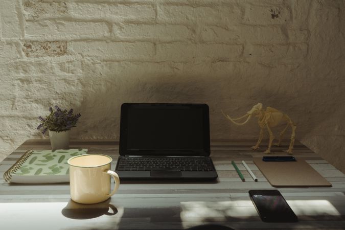 Metal mug near devices and stationery
