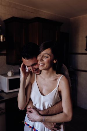 Happy couple embracing in kitchen