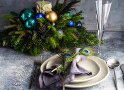 Festive table setting for Christmas dinner with peacock feathers