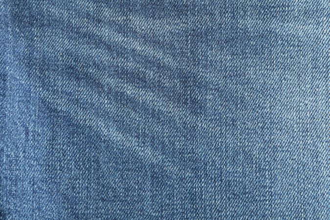 Texture of blue jeans as background, space for text