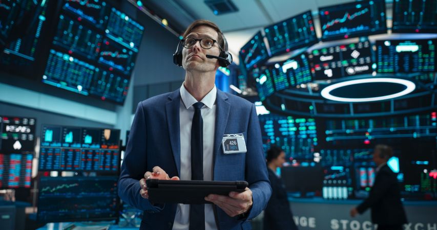Portrait of a Successful Stock Exchange Manager Wearing Headphones, Working in Modern Office.
