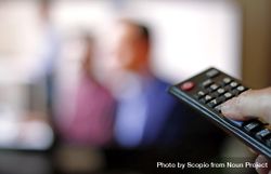 Person holding remote control with blurry image on TV screen 5p6Yeb