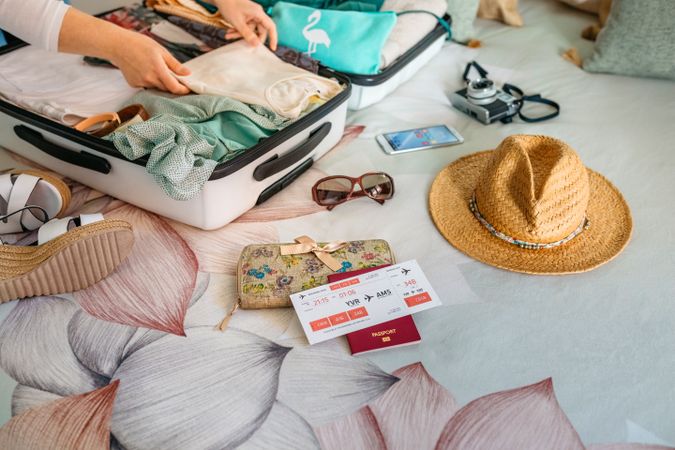 Unrecognizable woman preparing suitcase for summer holidays