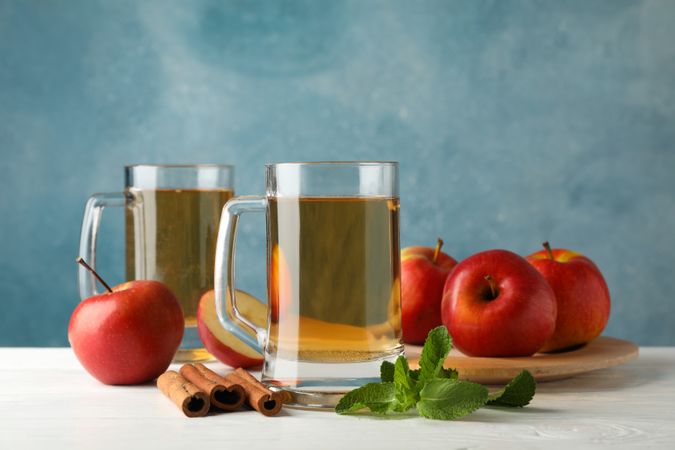 Composition with cider, cinnamon and apples on wooden background