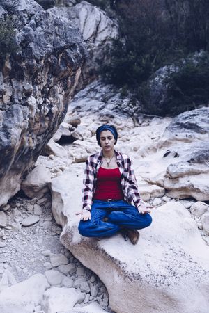 Positive woman sitting on stone