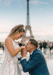 Bridegroom kneeling and kissing hands of bride