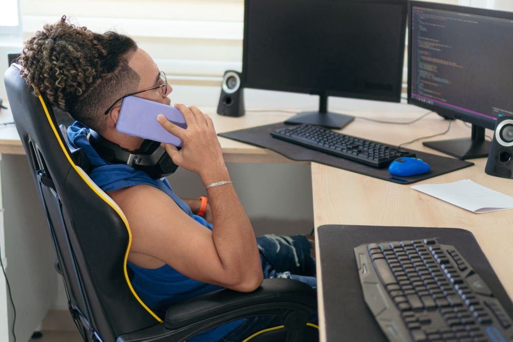 Man Talking On The Phone While Sitting At The Table At Home