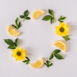 Round wreath of yellow flowers lemon slices and leave