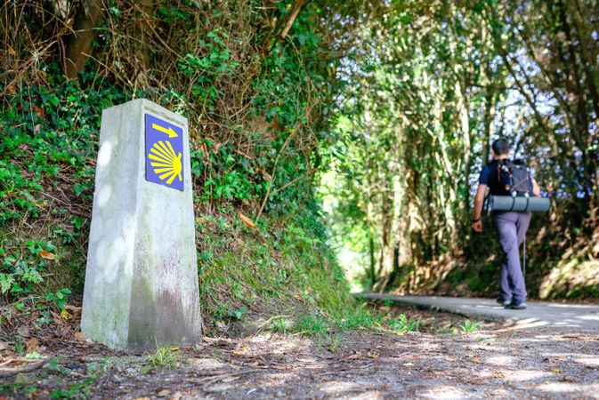 Signpost of Saint James way with pilgrim walking