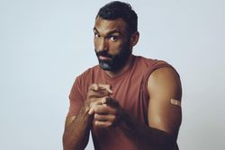Serious man pointing at camera to encourage vaccinations, copy space