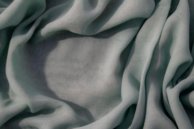 Nude green fabric wavy crumpled background texture with copy space.
