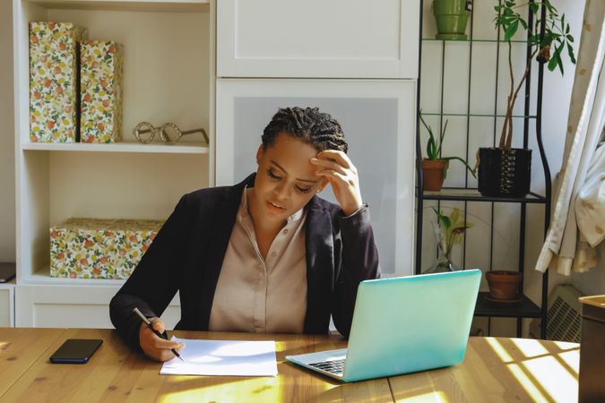 Female business owner concentrating on paper work in her home office