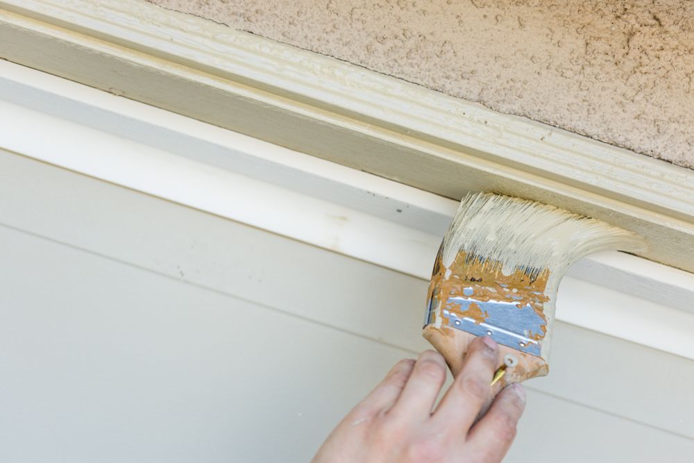 Professional Painter Cutting In With Brush to Paint Garage Door Frame