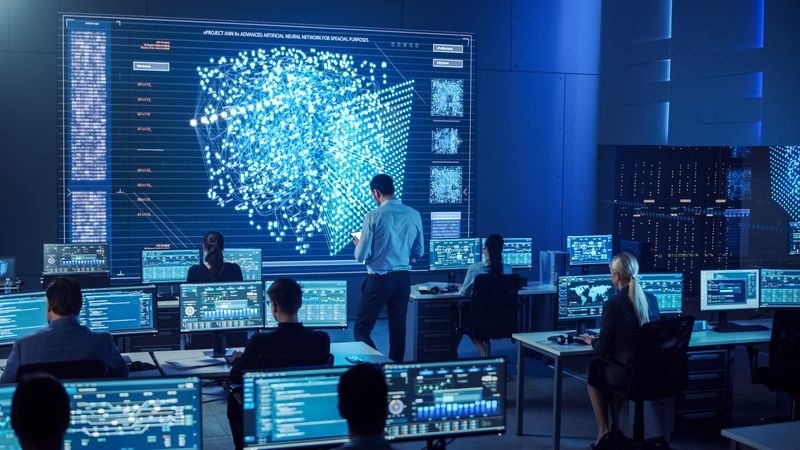 Diverse Team Analyzes Complex Data on Digital Screens in a High-tech Control Room, Ensuring Cybersecurity and Operational Efficiency.