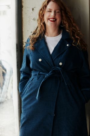 Stylish woman with curly hair smiling with eyes closed