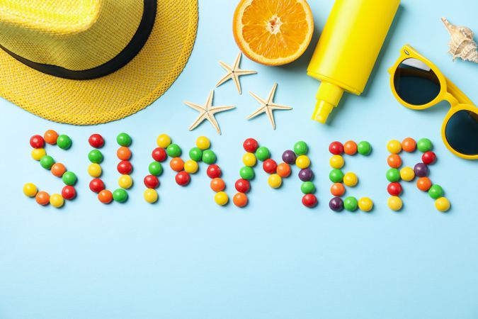 Word Summer and vacation accessories on blue background, top view