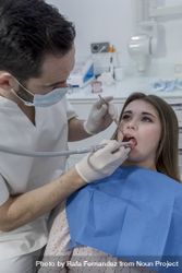 Portrait of a dentist and a teenage patient in the dentist clinic, vertical 47gLr4