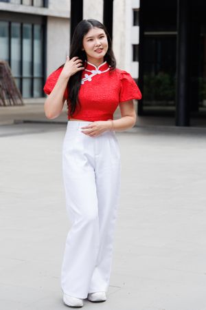 Asian woman in Chinese New Year outfit standing in the city