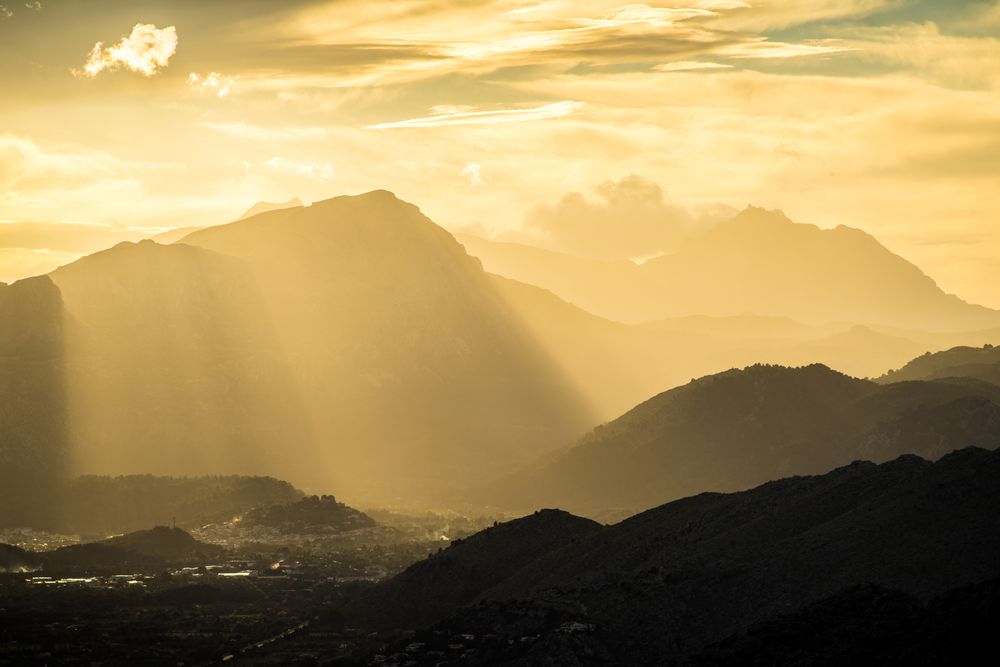 Majestic mountain in sunbeams under cloudy sky