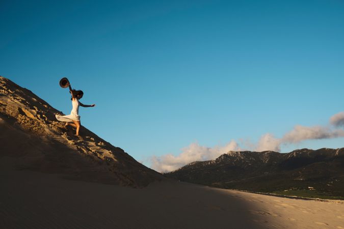 Woman running down sandy hill
