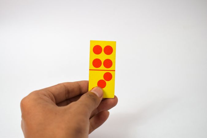 Person holding single domino cards