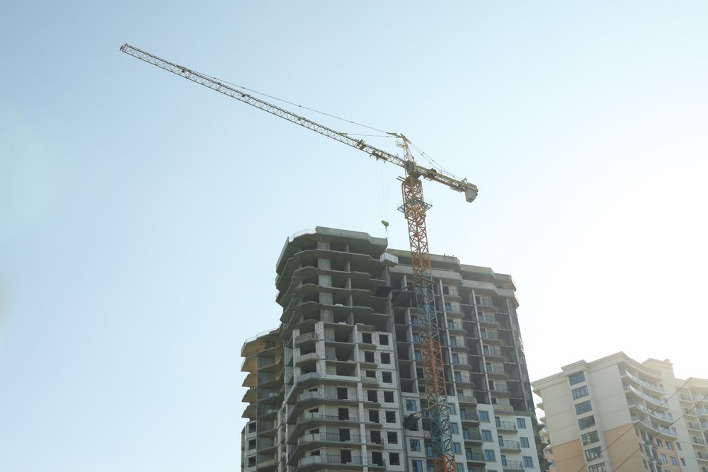 High-rise construction with crane against blue sky