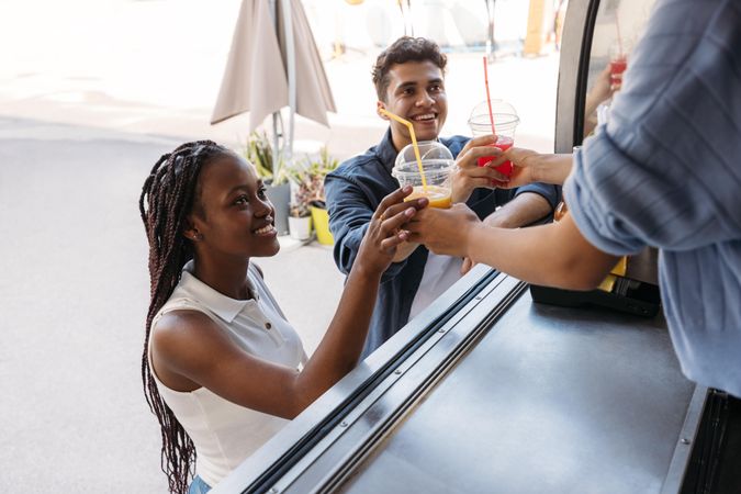 Man and woman buying drinks from food vendor