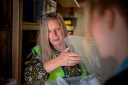 Older woman looking into a bin in stock room