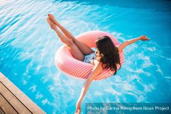Woman floats in a swimming pool in an inflatable ring a4Ojj5
