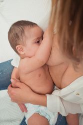mother breast feeding and hugging baby