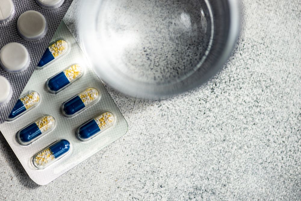 Top view of pills and glass of water