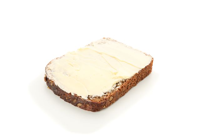 Rye bread piece with butter isolated on blank background. Bakery products