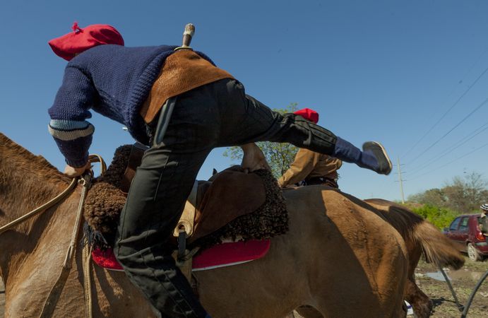 Faceless man riding horse in farm