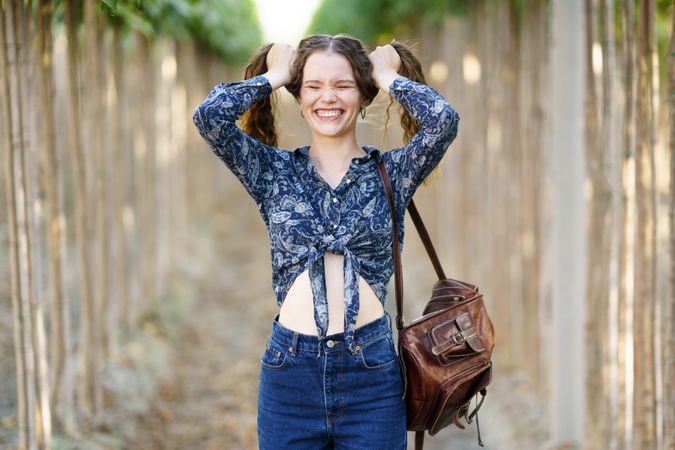 A Joyful Young Woman Wearing a Colorful Floral Top, Delightfully Enjoying the Beauty of Nature