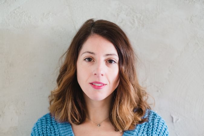 Charming woman in sweater near wall