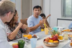 White couple having dinner with Asian relatives