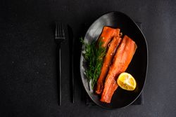 Looking down at herring fish with dill and lemon served on plate