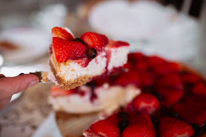 woman hand cutting strawberry cake with knife