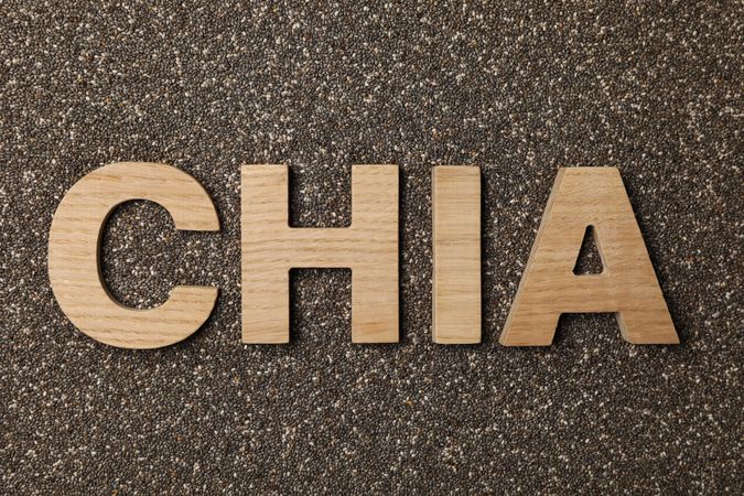 Word chia layout of wood letters on chia seeds background, top view